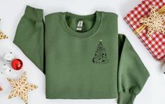 Holiday Sweatshirt-Embroidered Christmas Sweatshirt--Cat Sweatshirt-Holiday Sweater-Christmas Shirt-Christmas Sweater-Cat Christmas Tree-Gingerbread-Santa Cat-Merry and Bright This made to order embroidered holiday sweatshirt is super soft, unisex in size and makes a trendy sweatshirt to wear as the holiday season approaches. Embroidered Cat Christmas Tree design on center chest measures approximately 4" in height by 3" in width. Design will be embroidered in colors of your choosing. * Main photo shows Military Green Sweatshirt with Black and Beige thread * Second photo shows Ash Sweatshirt with Black and Red thread * Third photo shows Carolina Blue Sweatshirt with Black and Red thread * Fourth photo shows Sand Sweatshirt with Black and Red thread * Fifth photo shows White Sweatshirt with Gingerbread Santa, Christmas Tree Sweater, Embroidered Cat, Maroon Sweatshirt, Santa Cat, Cat Christmas Tree, Tree Sweater, Navy Blue Sweatshirt, Embroidered Christmas