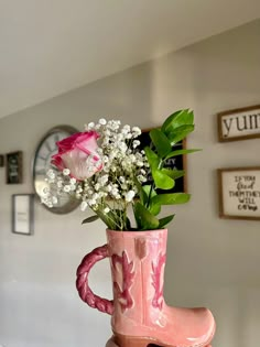 a pink boot vase with flowers in it