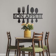 a table with four chairs and a vase filled with flowers