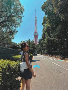 a woman standing on the side of a road