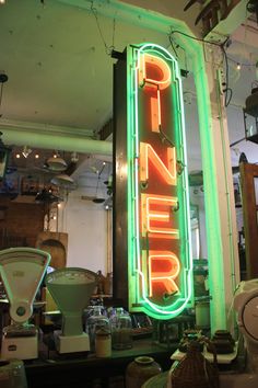 a neon sign that is on the side of a wall in a room with other items