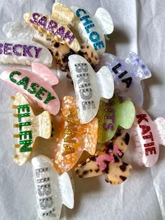 there are many different types of hair clips on the table together, including one with words that spell out their name