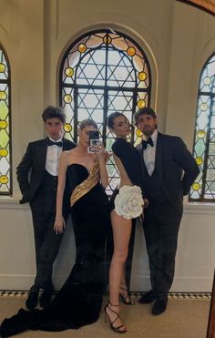 three men and a woman taking a selfie in front of a stained glass window