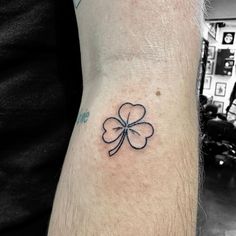 a small four leaf clover tattoo on the wrist