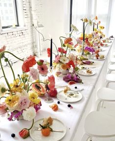 a long table with plates and flowers on it