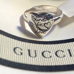 New With Tags. Gucci Box, Pouch & Papers. Gucci Ring. Band Ring In Sterling Silver. Graphic Engraved With Symbolic Gucci Motifs. Heart Shaped Face. The Front Features Eye, Heart And The Phrase Blind For Love. Bird And Flowers Adorn The Back. Size 7.5. Gucci Sterling Silver Ring, Classic Gucci Sterling Silver Rings, Gucci White Gold Sterling Silver Ring, Gucci Silver Sterling Silver Rings, Gucci Jewelry For Valentine's Day Anniversary, Gucci Rings With Polished Finish For Gift, Gucci Engraved Jewelry For Anniversary, Gucci Wedding Rings Fine Jewelry, Designer Gucci Jewelry For Valentine's Day