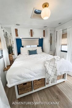 a white bed sitting inside of a bedroom on top of a wooden floor