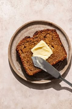 a piece of bread on a plate with butter