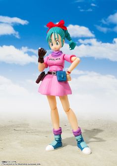 a girl in a pink dress holding a baseball bat and mitt on the beach