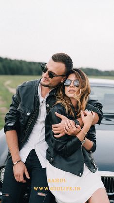 a man and woman hugging in front of a car