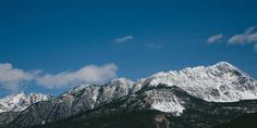 the mountains are covered in snow under a blue sky