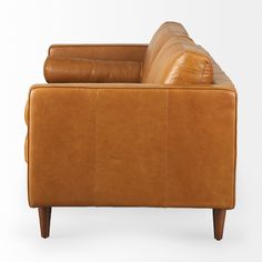 a tan leather couch sitting on top of a white floor