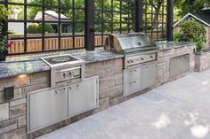 an outdoor kitchen with stainless steel appliances and grill