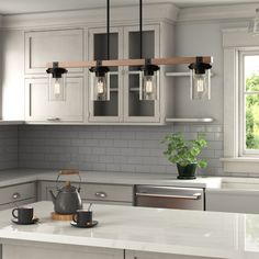 a kitchen with white cabinets and gray counter tops