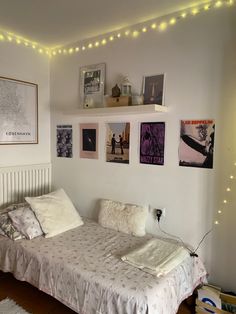 a small bedroom with white walls and string lights