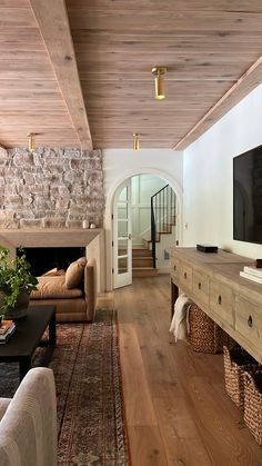 a living room filled with furniture and a flat screen tv on top of a wooden table