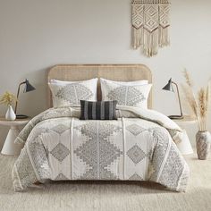 a bed with white and grey comforters in a bedroom