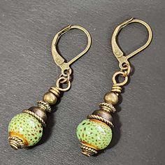 "If you love vintage things, and rustic/retro style, you will love adding these earrings to your collection. Hand crafted with handmade ceramic clay beads in speckled green round beads. Accent beads are metal. These earrings are so cute! Ceramic beads are about 9mm These earrings are about 1.5 inches long including the ear wires.  The metal is antiqued bronze colored. The earwires are alloy (nickel-free, lead-free, cadmium-free) which is good for most people with sensitive ears. Ear wires are le Handmade Retro Jewelry For Everyday Wear, Vintage Gold Beaded Earrings, Handmade Retro Everyday Jewelry, Vintage Dangle Earrings With Lever Back, Adjustable Nickel-free Retro Earrings, Adjustable Retro Drop Earrings, Retro Adjustable Drop Earrings, Handmade Vintage Beaded Earrings With Round Beads, Vintage Beaded Earrings With Ear Wire As Gift