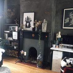 a living room filled with furniture and a fire place in the middle of a wooden floor