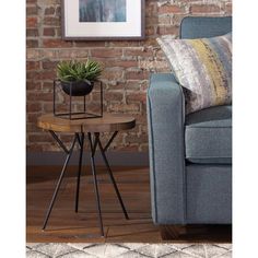 a living room with a couch, table and brick wall