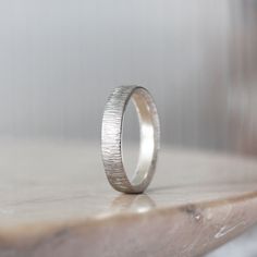 a silver ring sitting on top of a wooden table