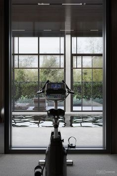 an exercise bike sitting in front of large windows