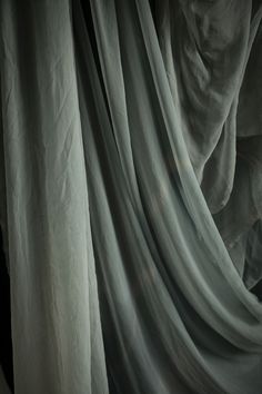 a man is peeking out from behind a curtain with his hand on the curtains edge