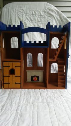 a wooden doll house with stairs and furniture