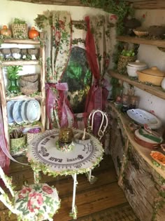 a table and chairs in a room with many items on the shelves behind it,