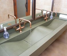 a bathroom sink with two faucets and soap dispenser