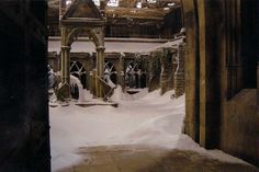 an old building with snow on the ground and arches in the front, looking out into the distance