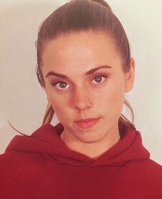 a young woman wearing a red hoodie and looking at the camera with an evil look on her face