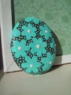 a decorative blue and black object sitting on top of a white table next to a green wall