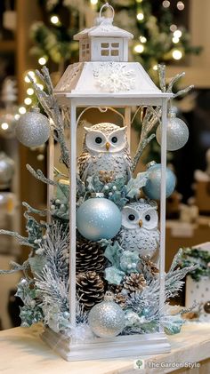 an owl figurine sitting on top of a table next to ornaments and trees