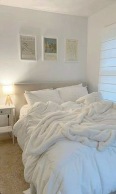 an unmade bed with white sheets and pillows