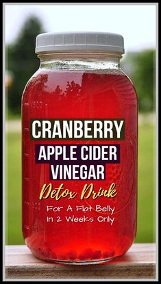 a jar of cranberry apple cider vinegar sits on a wooden table outside