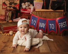 a baby is laying on the floor in front of some signs