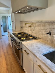 a stove top oven sitting inside of a kitchen next to a sink and countertop