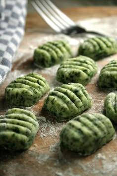 some green cookies are on a table with a fork