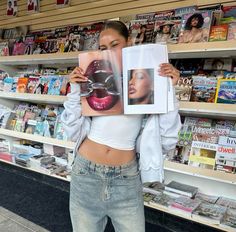 a woman holding up a magazine in front of her face