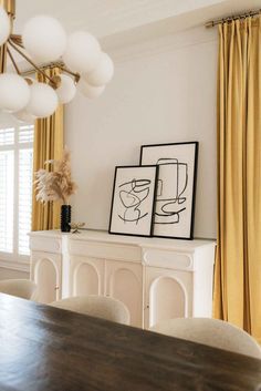 a dining room table with chairs and pictures on it