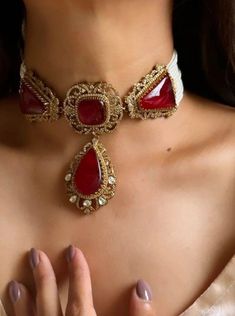 Discover the timeless elegance of the Red Victorian Gold Sabyasachi-inspired uncut polki Kundan choker necklace. This exquisite Indian bridal jewelry piece showcases a stunning blend of traditional craftsmanship and modern luxury. Adorned with uncut polki stones and intricate Kundan work, the necklace features a rich red and gold palette, capturing the opulence and grandeur reminiscent of Bollywood glamour. Perfect for brides seeking to make a regal statement, this choker combines classic Victor Luxury Red Bollywood Earrings, Ruby Victorian Necklace, Luxury Kundan Bridal Earrings With Intricate Design, Luxury Red Kundan Necklace For Festivals, Luxury Red Kundan Temple Necklace, Luxury Red Kundan Jhumkas, Luxury Elegant Kundan Necklace, Luxury Diwali Choker With Intricate Design, Luxury Gold Kundan Necklace Statement Piece