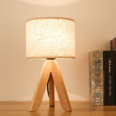 a wooden table lamp sitting on top of a desk next to a bookshelf