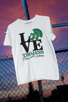 "Show off your hometown pride with this pop-culture-meets-the-NCHS Trojans original design! A mashup of New Castle, Indiana's own, Robert Indiana's famous 1964 \"LOVE\" painting, AND the classic \"Trojan Warrior\" mascot logo - this design (by an N.C. grad and graphic artist) combines two of the community's great \"LOVEs\"! So show your TROJAN and NEW CASTLE PRIDE with this N.C. artist's tribute to other great N.C. artists! And don't forget to check out our selection of other T's, hoodies, and c Cotton Graphic T-shirt For Fan Gatherings, Fan Merchandise T-shirt With Custom Artwork And Crew Neck, Pop Culture T-shirt With Screen Print For Fan Gatherings, Pop Culture T-shirt With Screen Print For Fan Events, Graphic Tee With Letter Print For Fan Gatherings, Crew Neck T-shirt With Custom Artwork For Fans, School Spirit T-shirt With Screen Print For Fans, Retro Crew Neck T-shirt With Custom Artwork, Cotton Letter Print T-shirt For Fan Gatherings