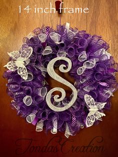 a purple and white wreath with the letter s on it