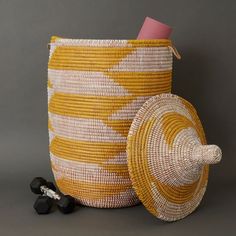 Large size storage basket with hooded lid in yellow and white pattern. Measures approx. 17" diameter, 23" without hood, and 30" height with hood. For storing laundry, toys or 8 throw blankets Woven from grass and recycled plastic ribbons using traditional coil weaving technique. Handmade by Wolof tribe women in Senegal, Africa. --------------------- The Wolof people in Senegal are known for weaving colorful baskets from locally harvested cattail stalks and strips of plastic. They weave handmade Large Basket With Lid, Hooded Lids, Small Storage Basket, Wine Bottle Topper, Colorful Baskets, Grass Basket, Mirror With Hooks, Large Storage Baskets, Handmade Baskets