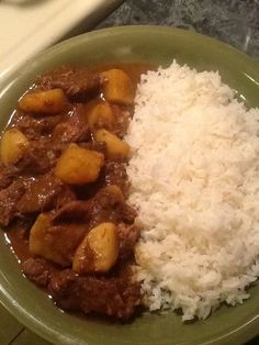 a green plate topped with rice and meat