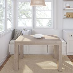 a table with a bowl on it in front of a window