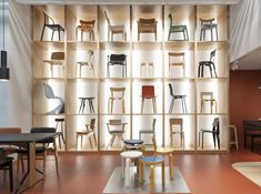 a room filled with lots of chairs and tables next to a book shelf full of books