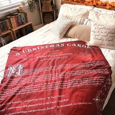 a bed with a christmas card on the comforter and pillows in front of it